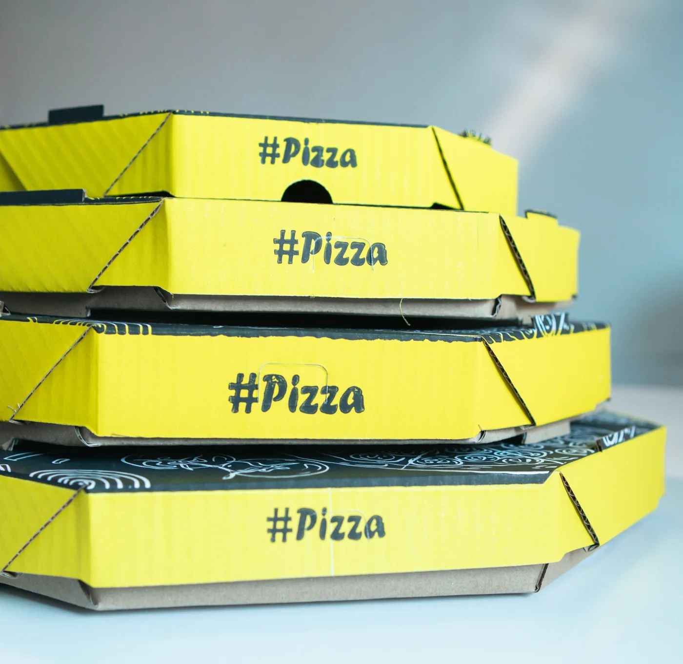 Pilha de caixas de pizza personalizadas produzidas pela AME
